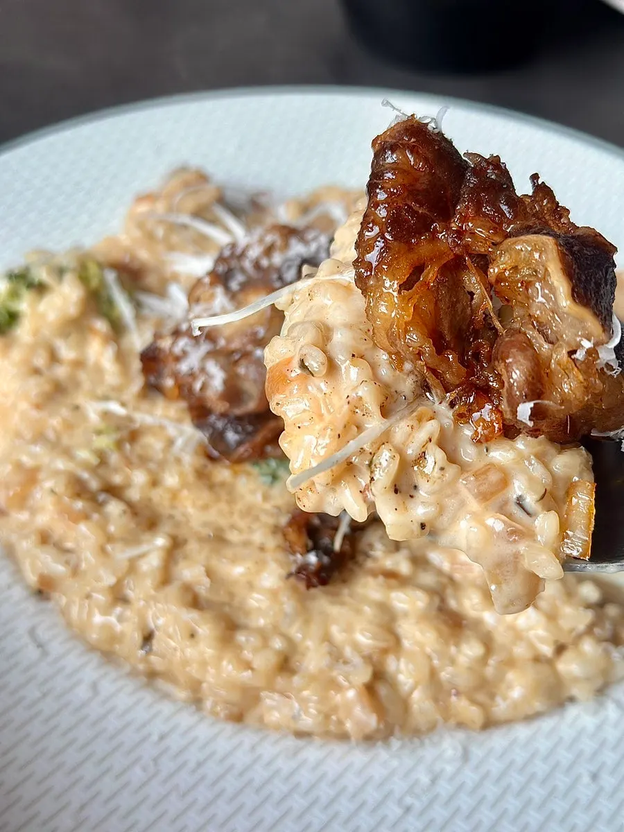 A spoonful of soft soy cream risotto topped with beef brisket