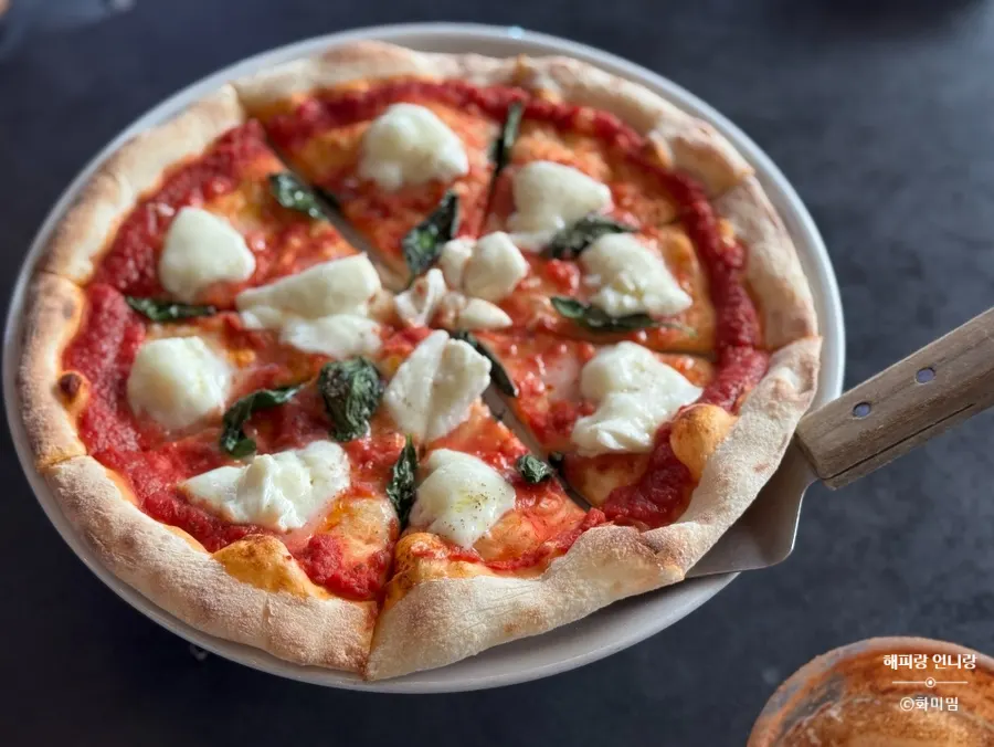 Table set with wood-fired pizza, pasta, and beer