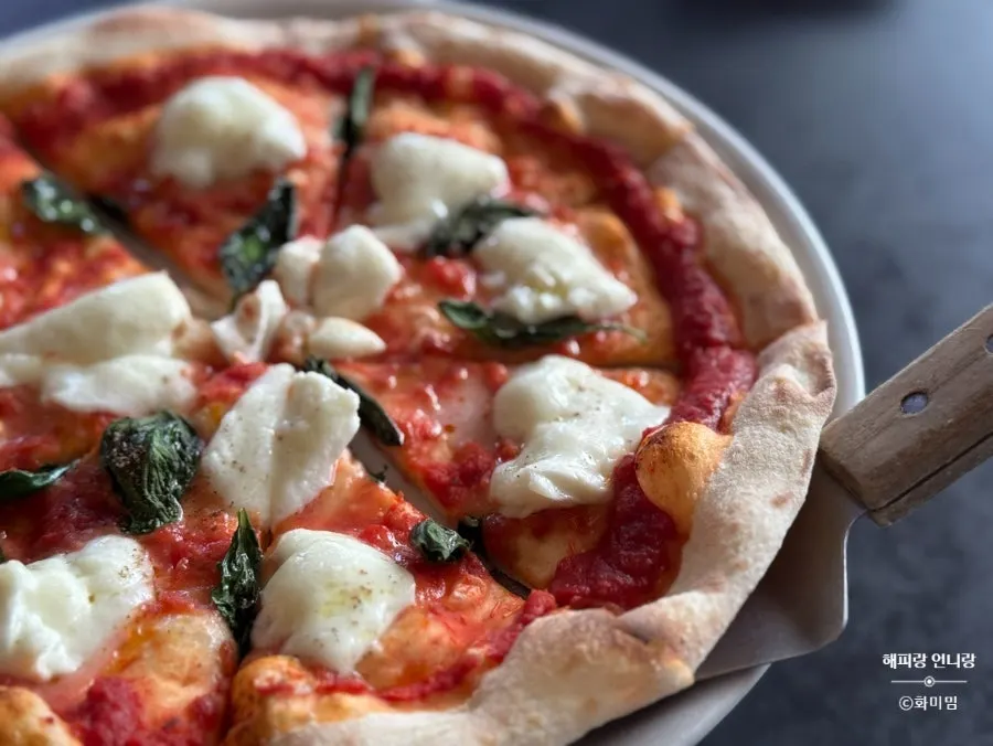 Table spread of wood-fired margherita and cream jjamppong pasta
