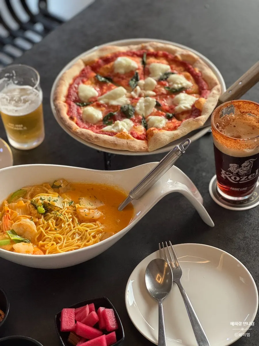 A slice of pizza paired with cream jjamppong pasta