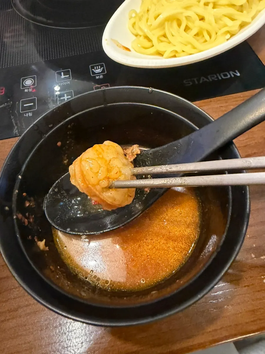 A spoonful of rice mixed into the broth
