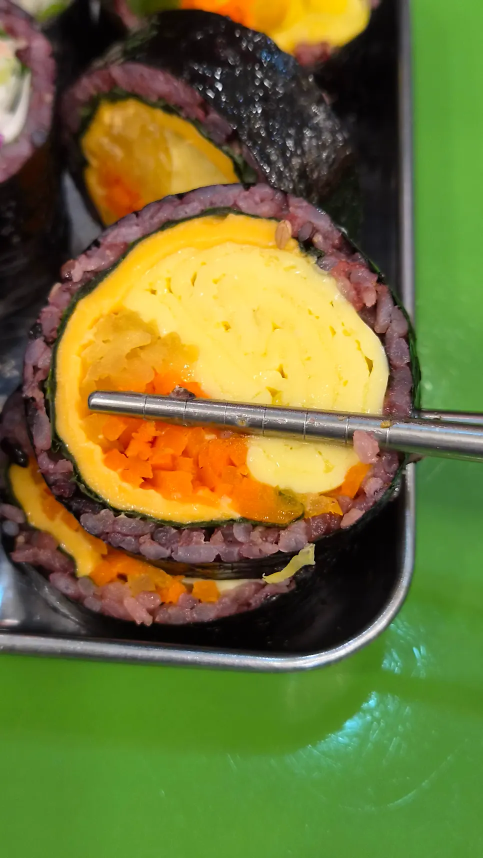 Cross-section of gimbap with yellow egg filling the center