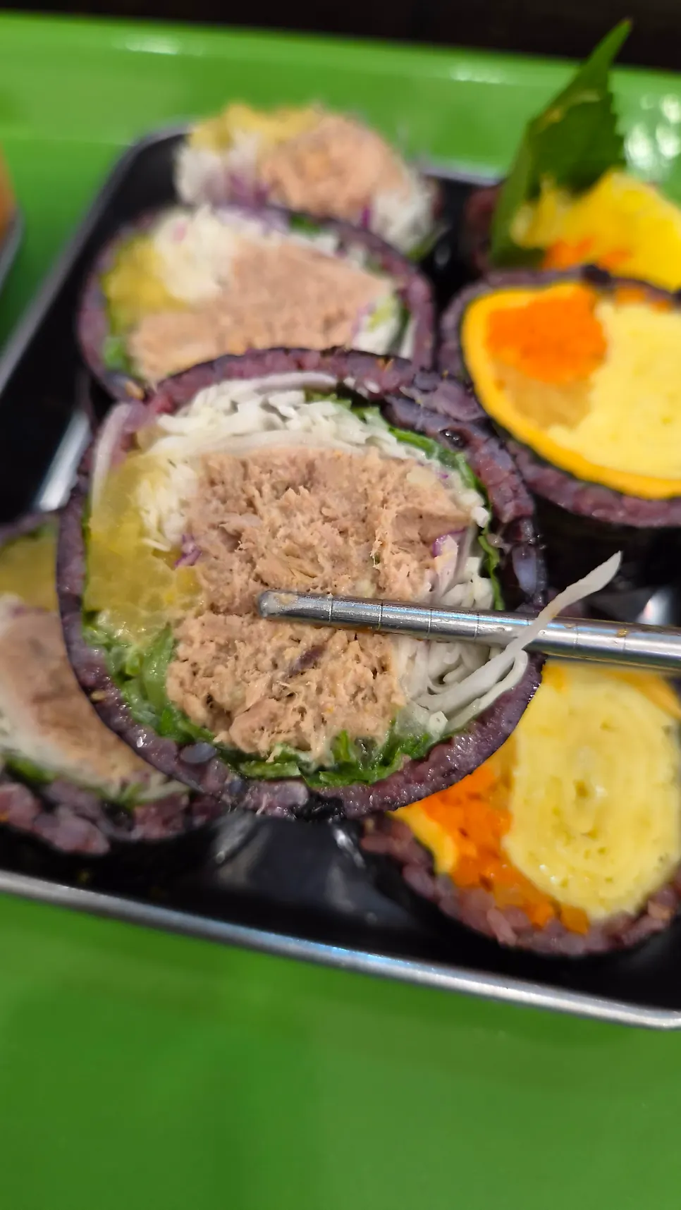 Cross-section of tuna-scallion gimbap packed with tuna and vegetables