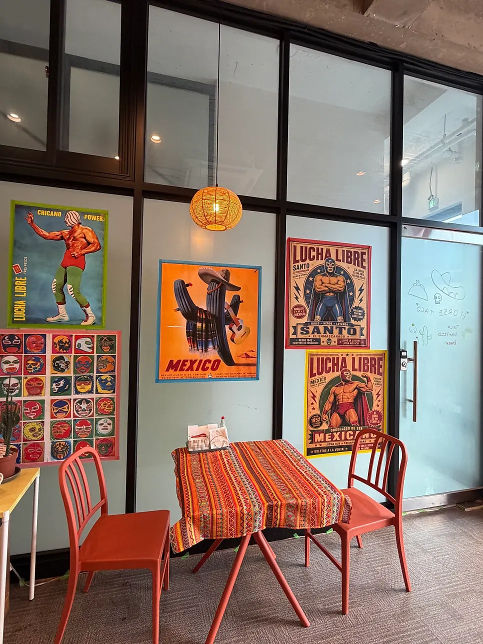 Corner of the restaurant with Mexican posters and cactus decor