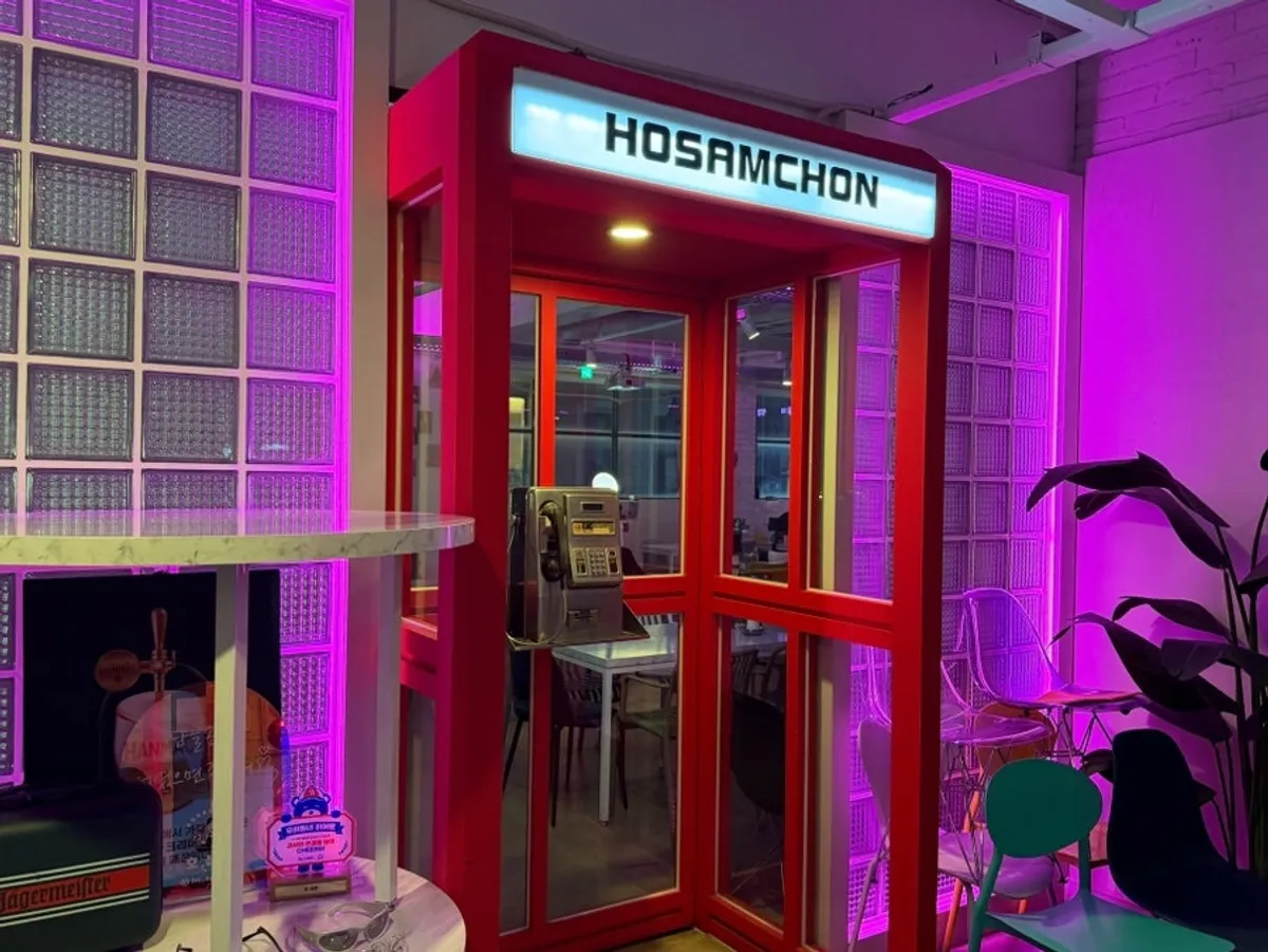 Ho Samchon entrance styled with pink lighting and a red phone booth