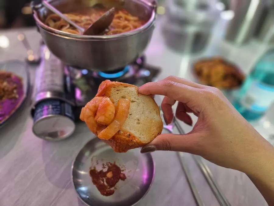 Baguette and shrimp dipped in tomato broth