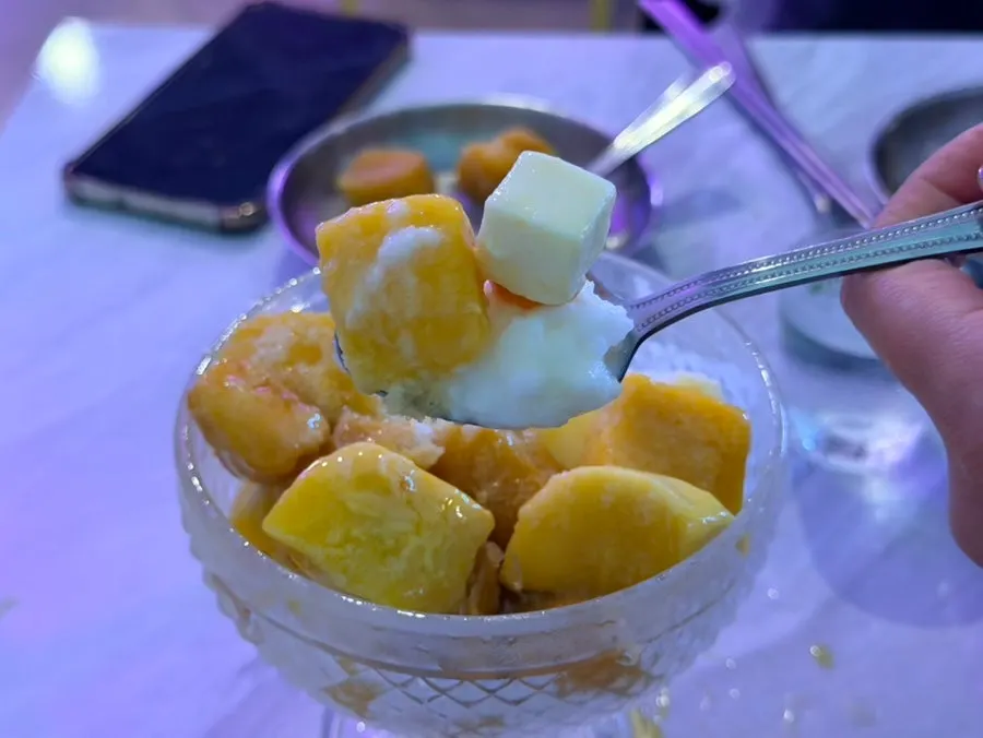 Close-up of shaved ice with large mango chunks