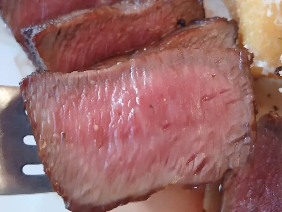 A piece of steak dipped in sauce
