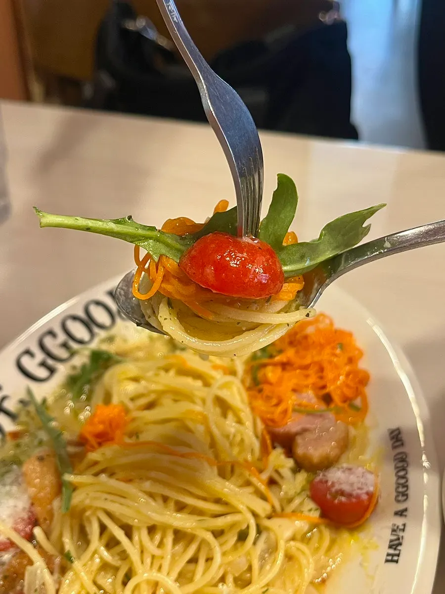 Aglio olio noodles lifted on a fork