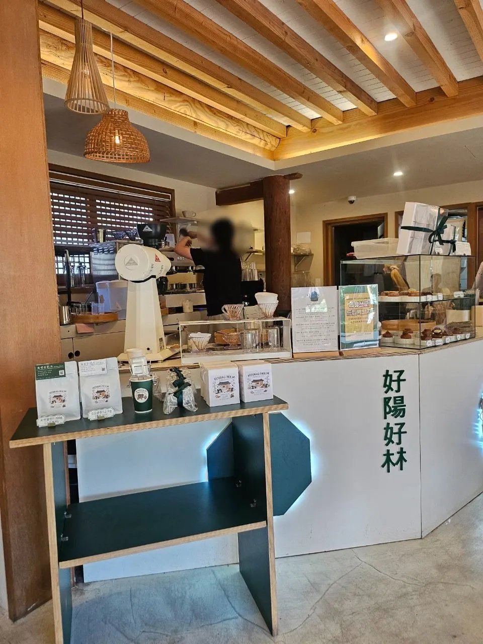 Bahagian dalam kafe dengan kaunter warna kayu dan lampu rotan