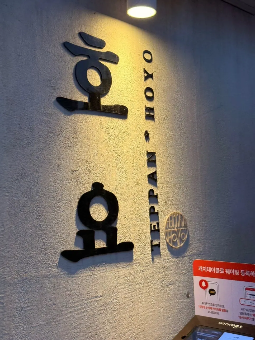 Wood-tone interior with the Hoyo logo on the wall