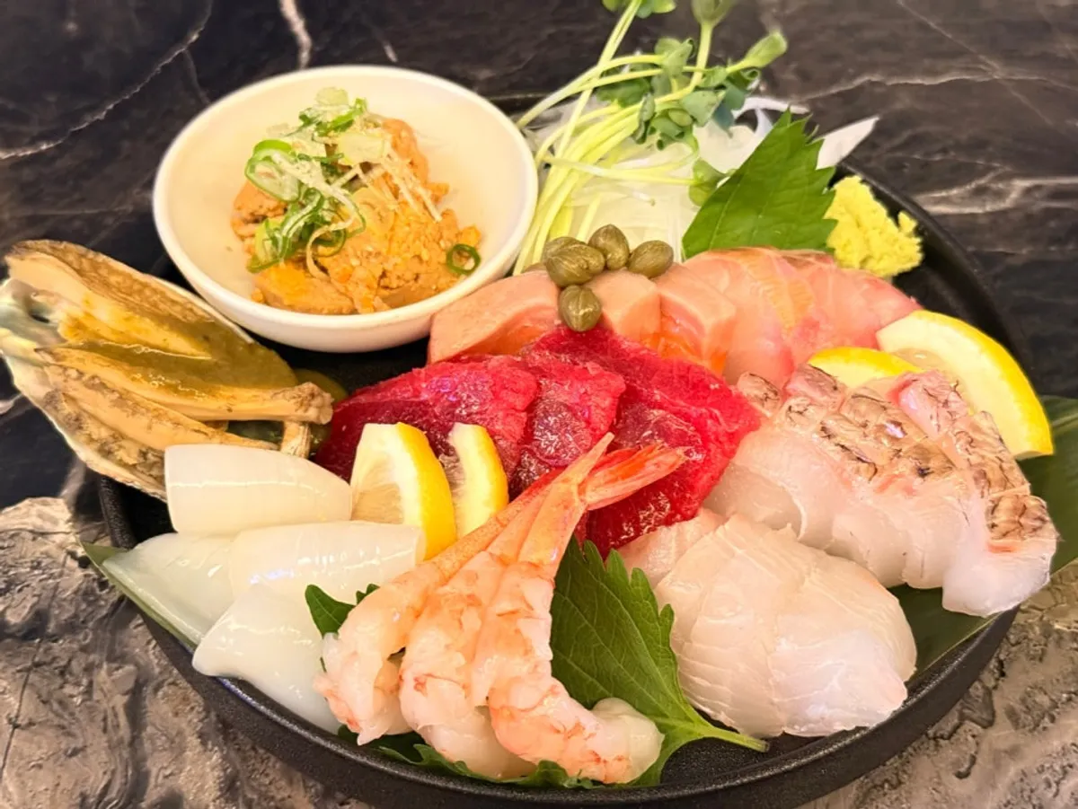 Plate of mixed sashimi with white fish, tuna, and shrimp