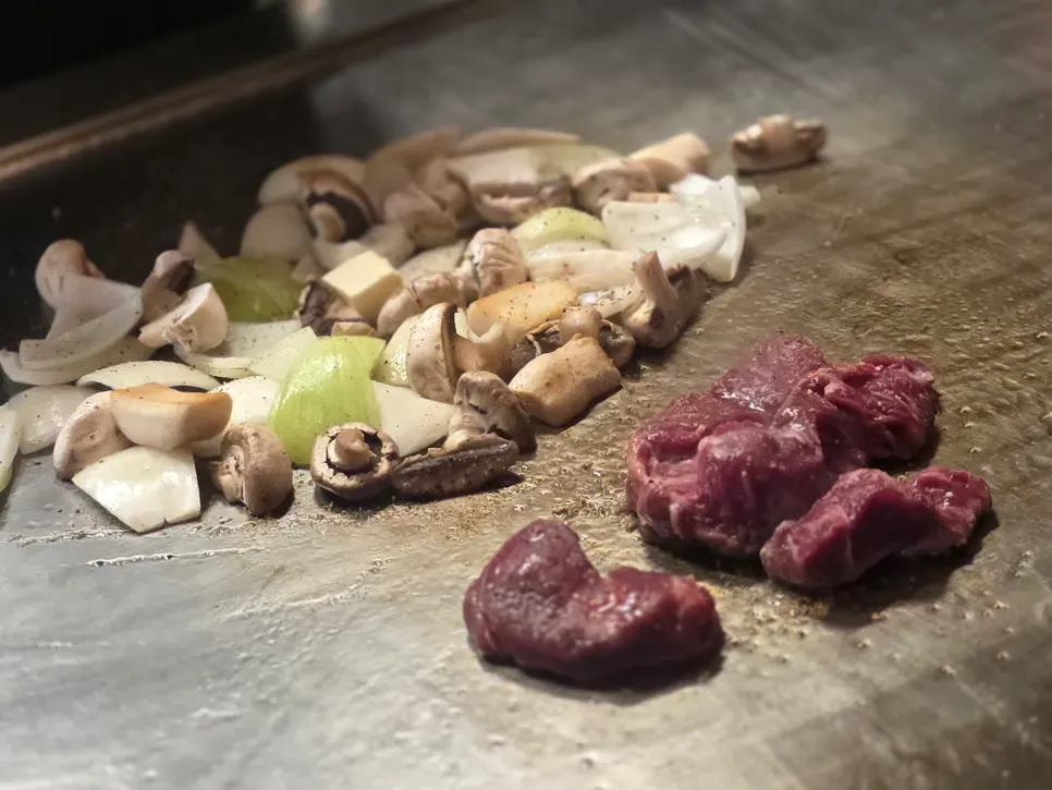 Thick-cut beef being grilled on the teppan