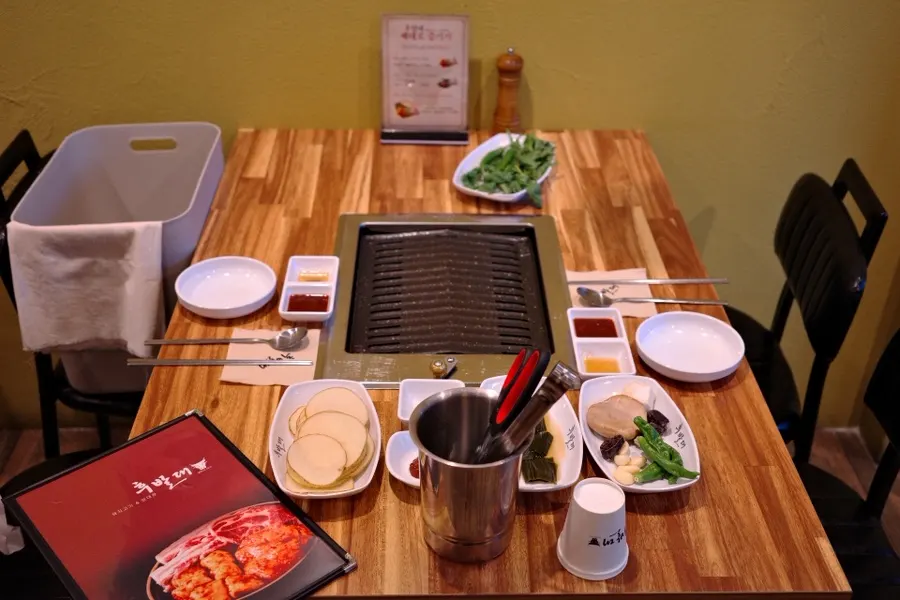 Staff grilling meat at a Hubaldae table