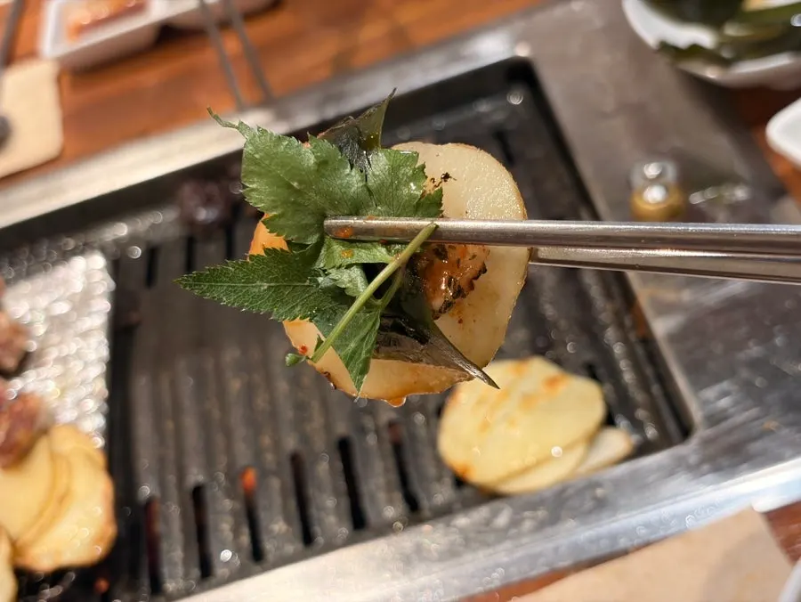 Pork neck cooking to a golden brown on the grill