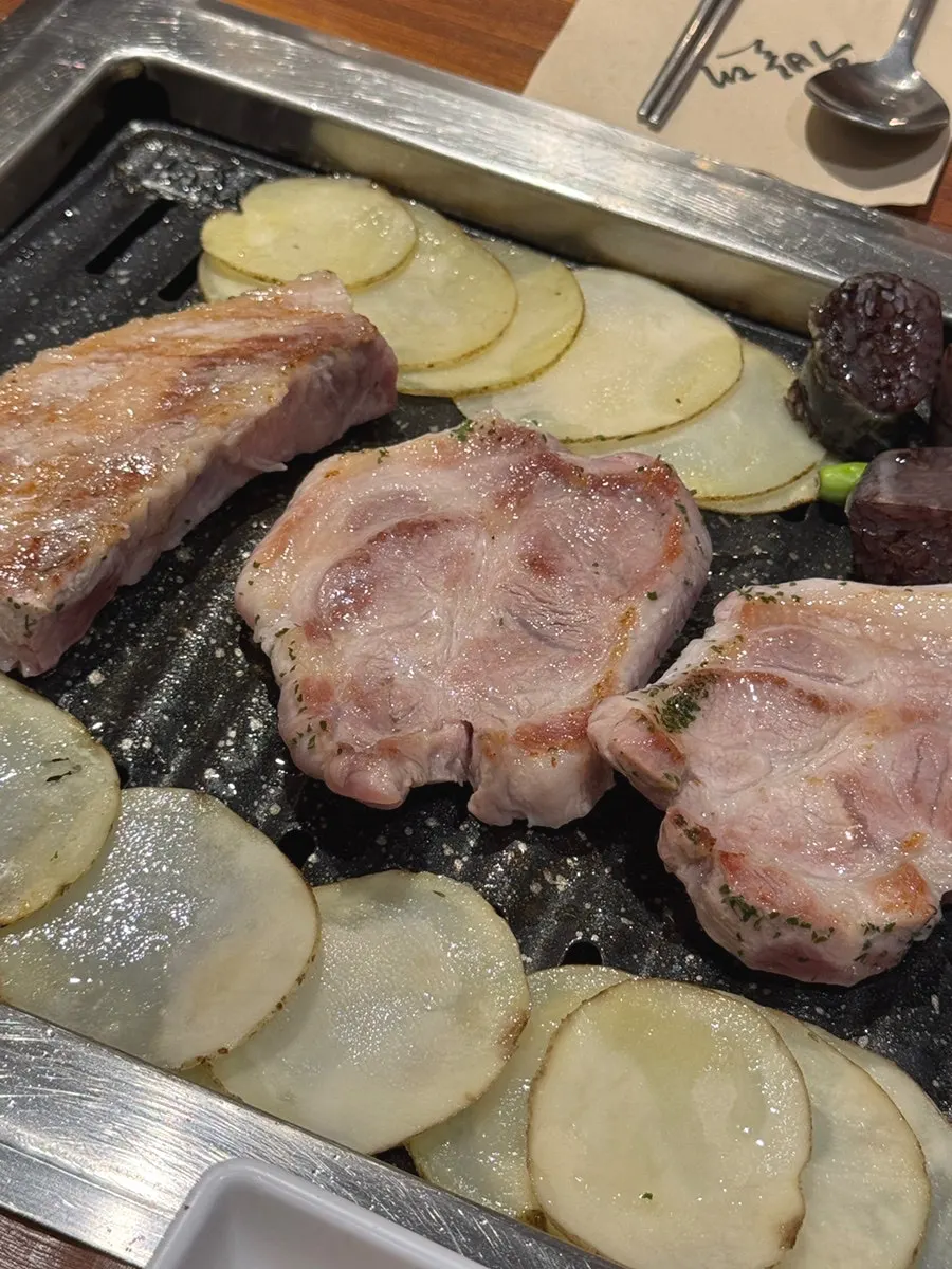 Staff member grilling meat on the tabletop grill