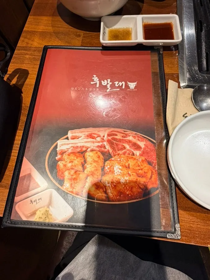 Menu board showing pork belly, pork neck, and grilled daechang at Hubaldae