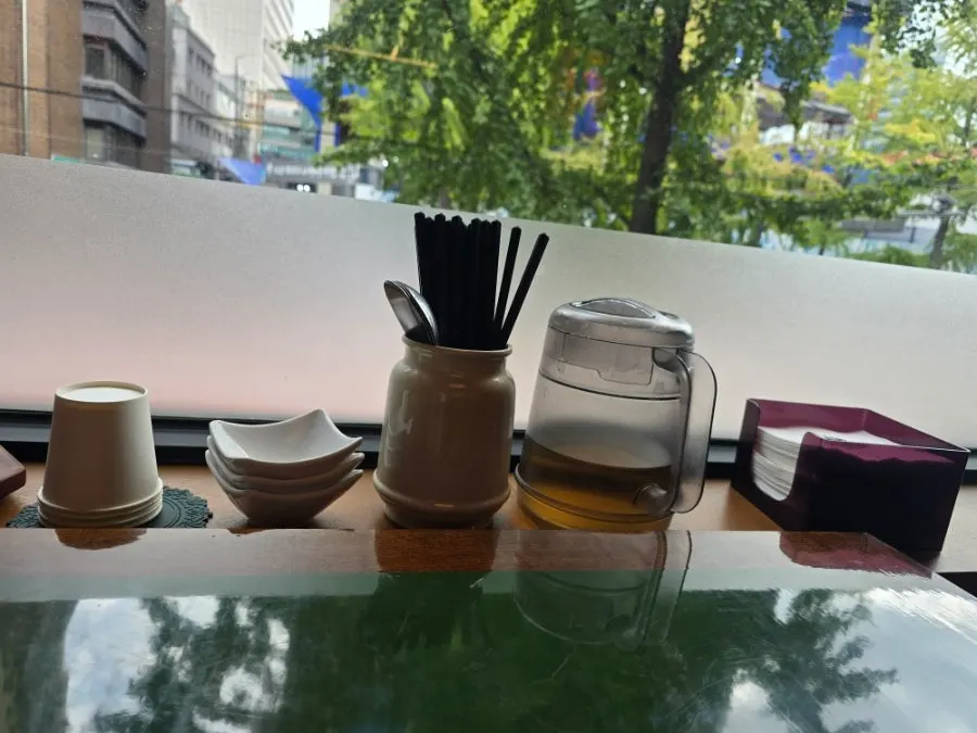 Table setting with paper cups, small dishes, and utensils