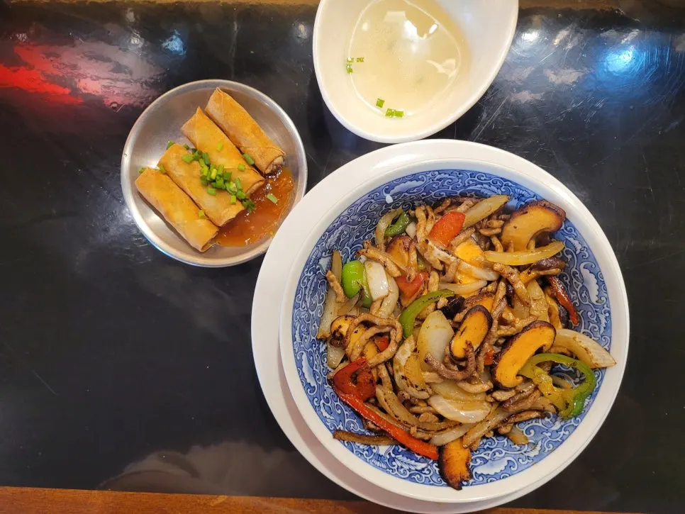 Table setting with pepper stir-fry rice, complimentary spring rolls, and basic egg soup