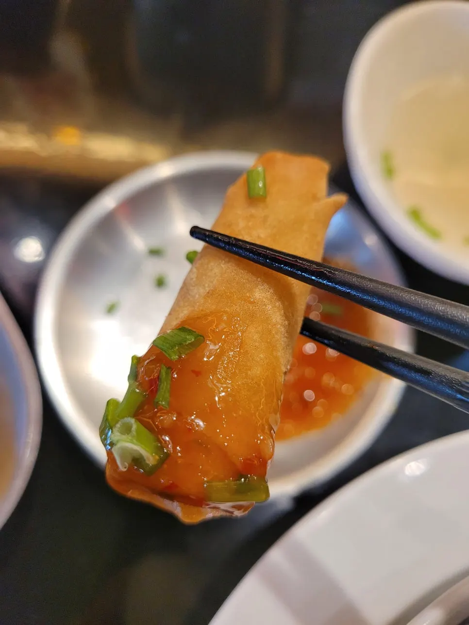 Gusungye mixed with cilantro alongside crispy spring rolls