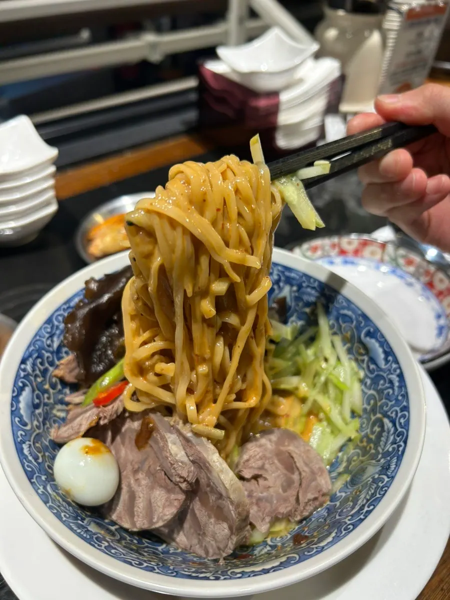 Close-up of mazangmyeon topped with peanut sauce