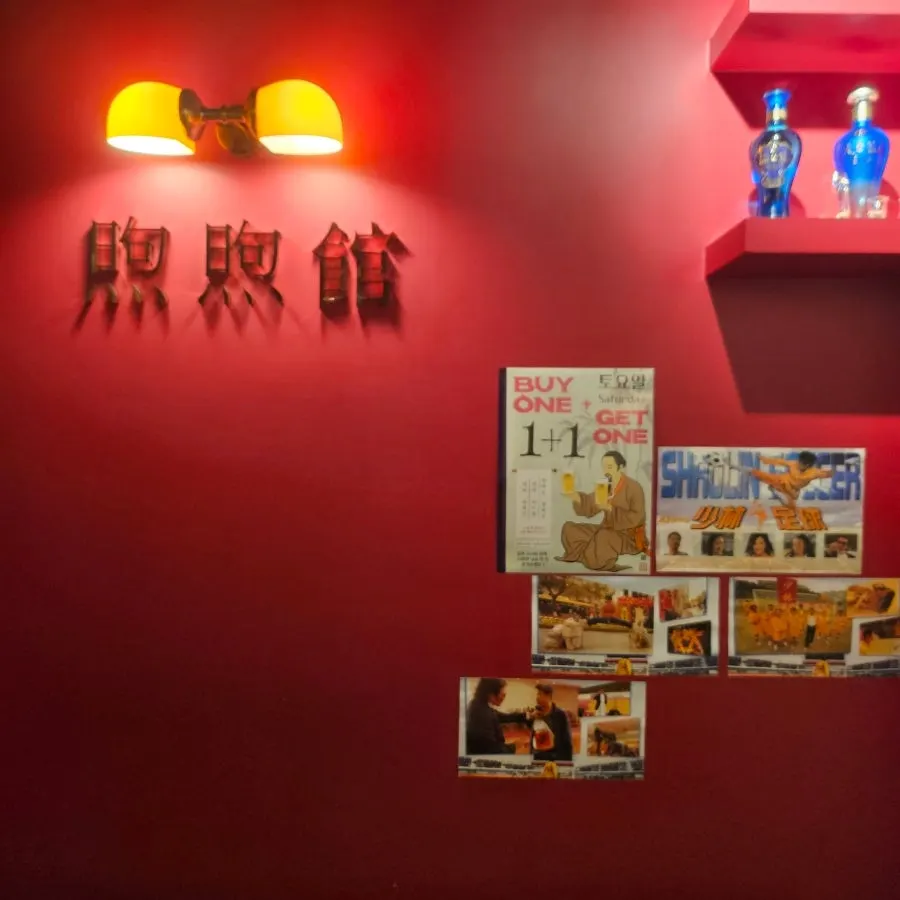 Stairs leading up to Huhugwan's 2nd floor with a Hong Kong-style poster