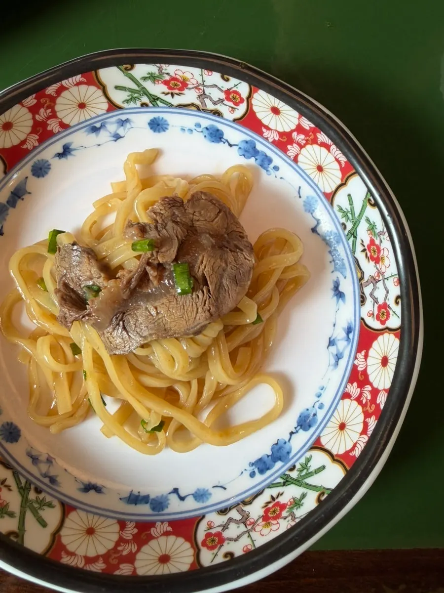 Noodles and meat lifted together from the beef noodle soup