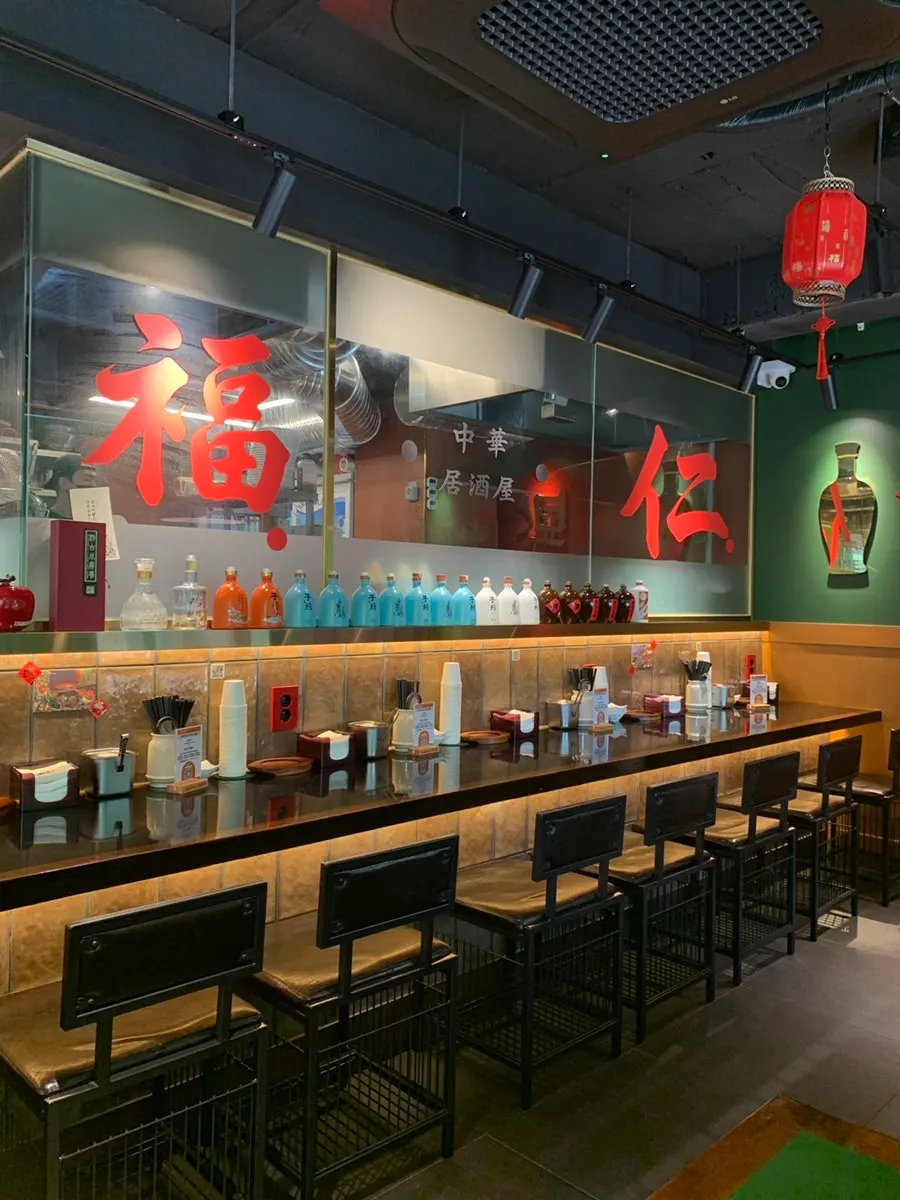 Bar seats in front of the glass wall overlooking the kitchen