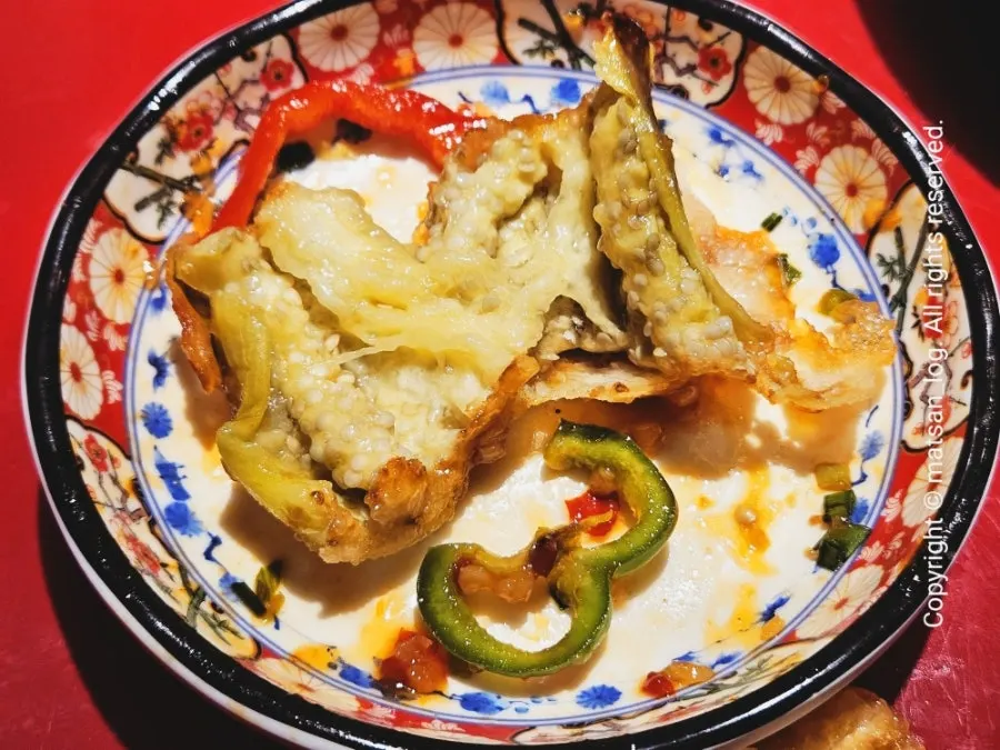 A plate of Huhugwan's fried eggplant topped with peppers