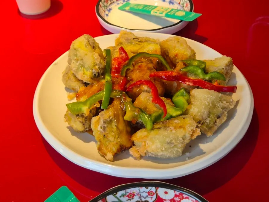 Eggplant fritters topped with sweet-and-sour sauce and peppers