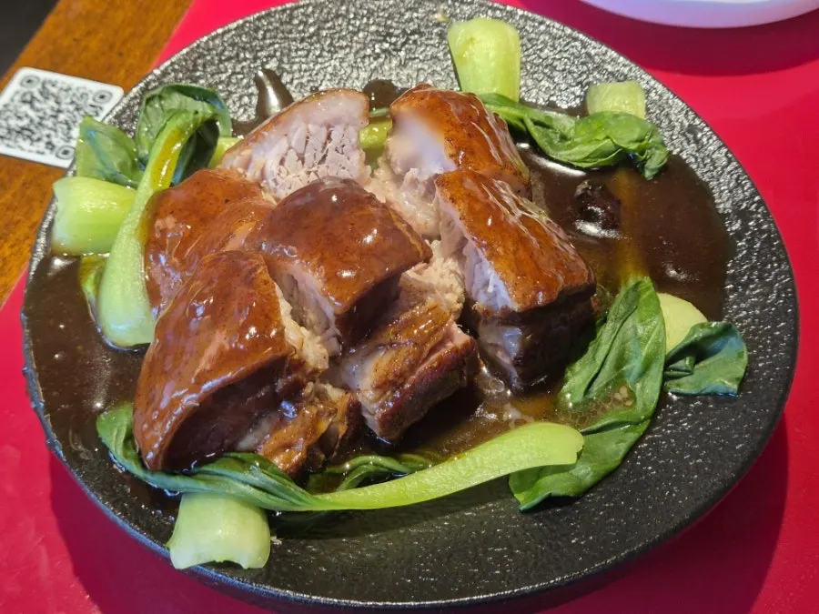 Braised pork belly plated with bok choy