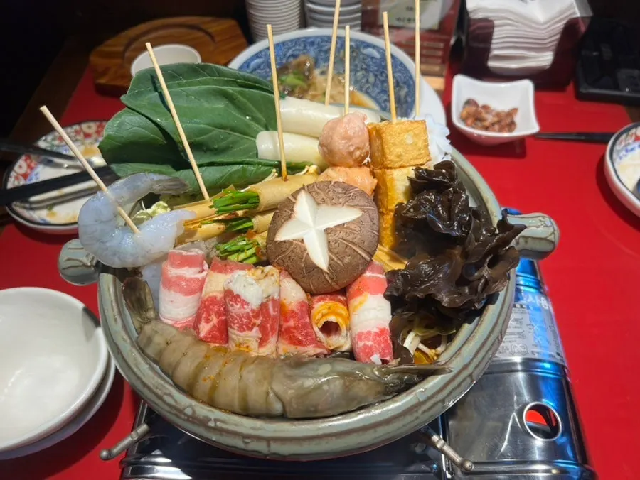 Huhuchuan mala hot pot topped with skewered ingredients