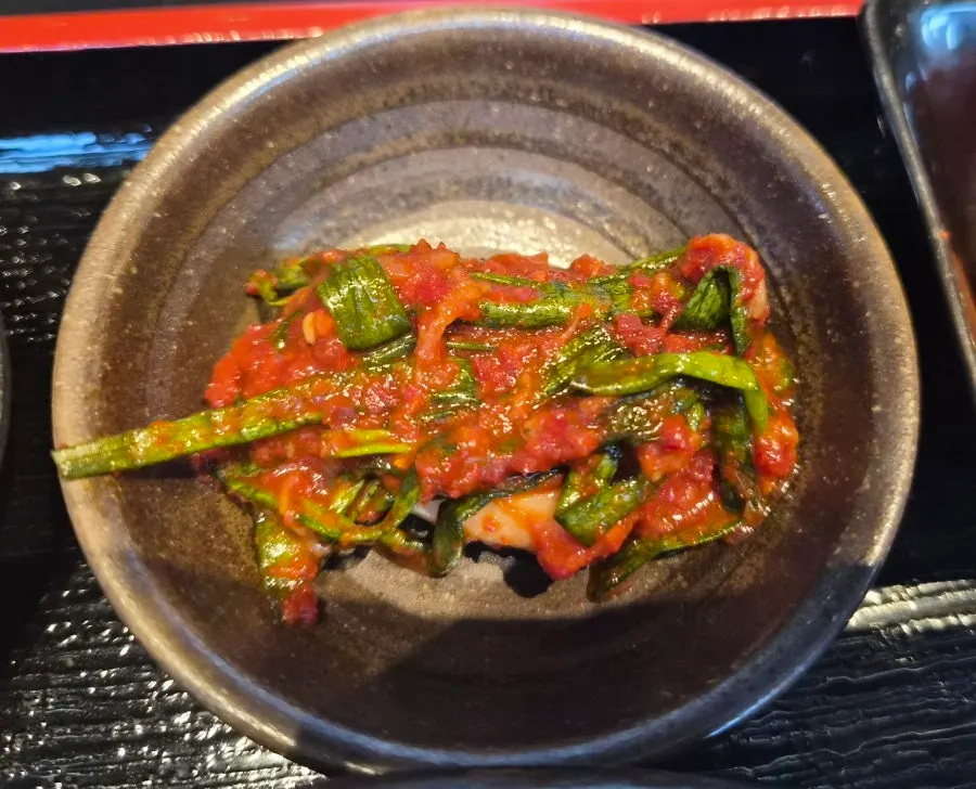 Scallion kimchi side dish served with the pork cutlet