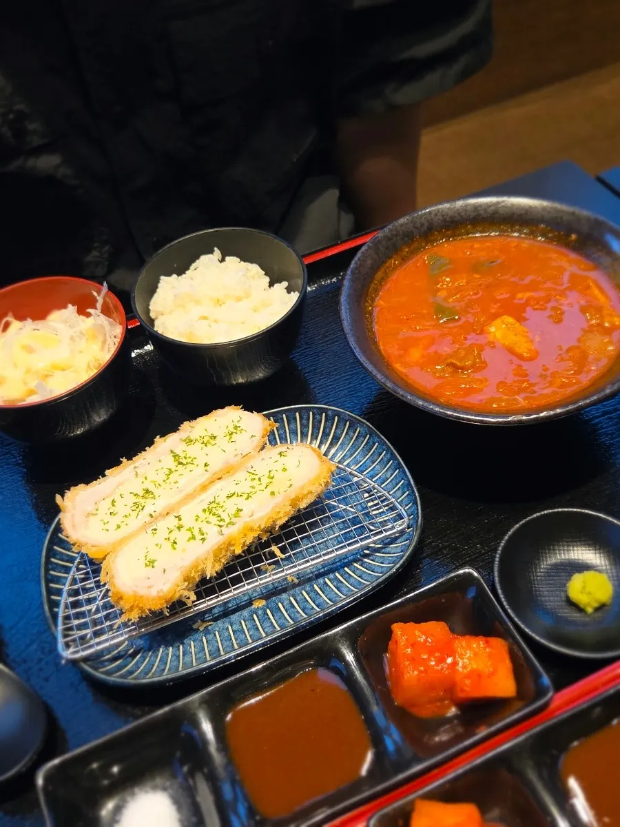 Table setting enjoying pork cutlet with kimchi jjigae together