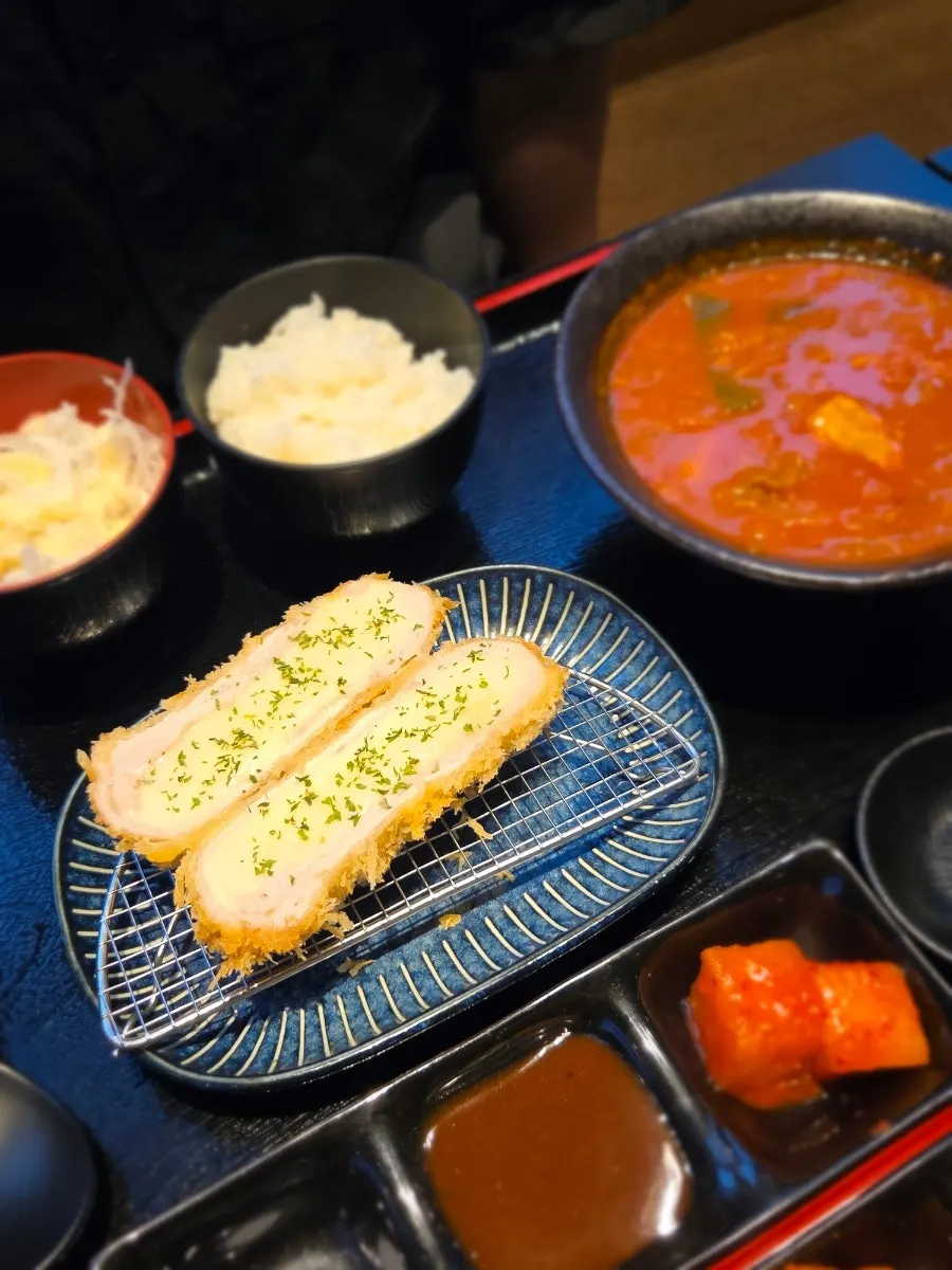 A bite of pork cutlet with side dishes