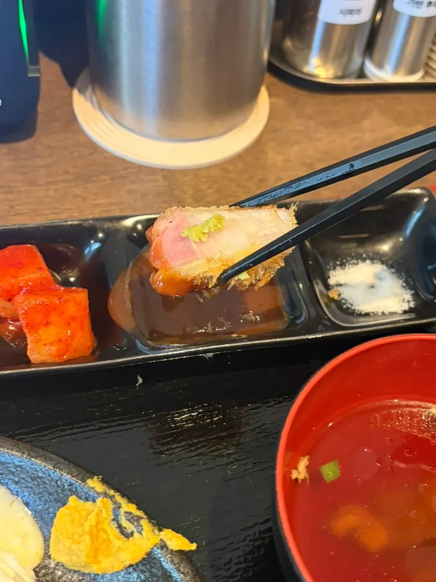 A piece of premium loin katsu picked up with chopsticks