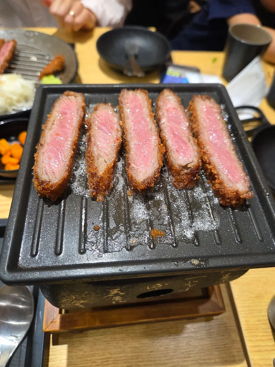 Gyukatsu placed on the grill with melted butter