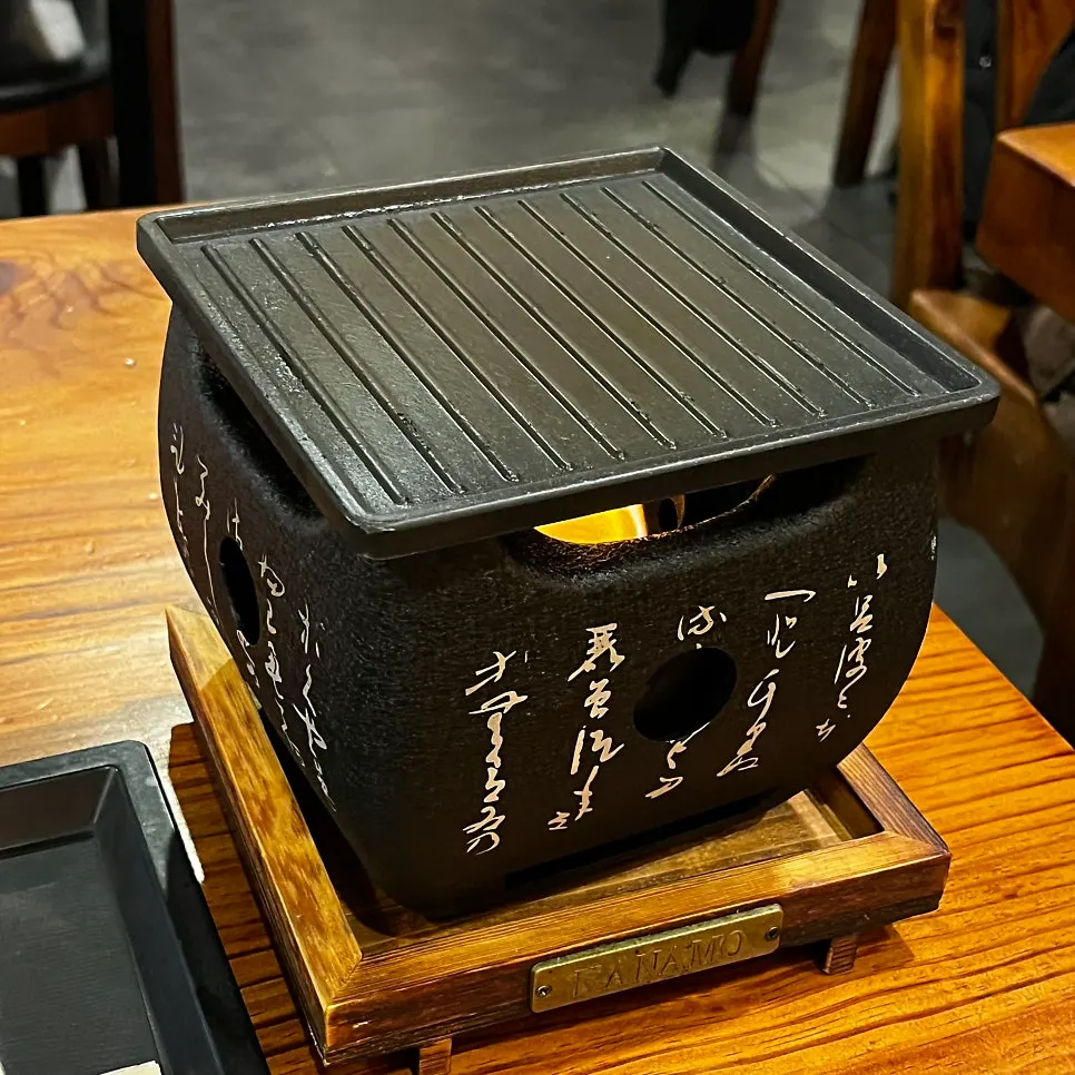 Grilling gyukatsu on a personal charcoal stove