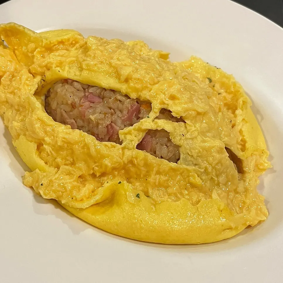 Bacon fried rice inside the omurice with the soft-boiled egg split open