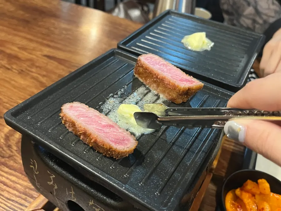 Gyukatsu cooking on both sides over the butter