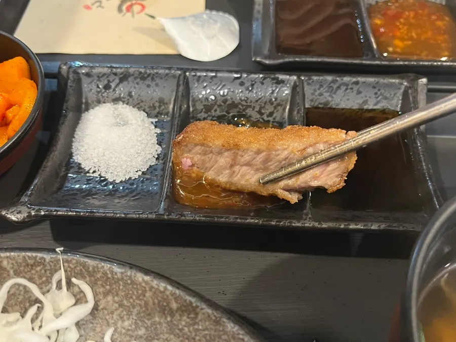 A bite of gyukatsu eaten with rice