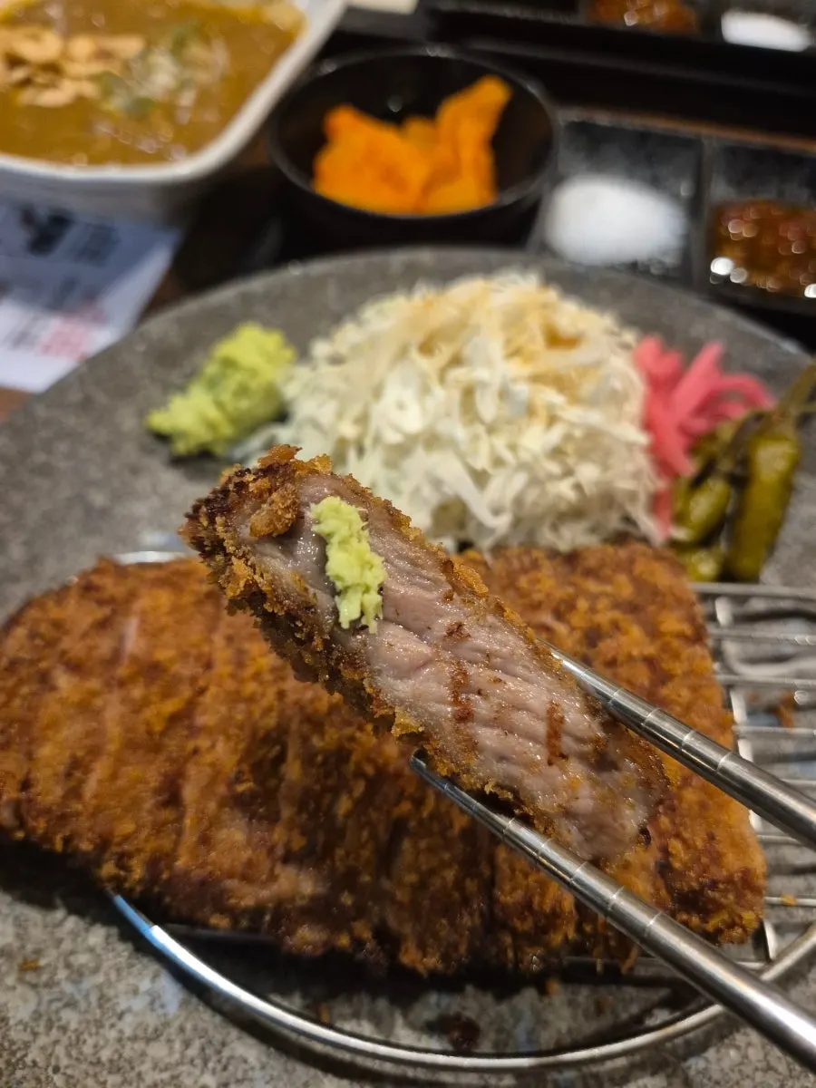 Fully cooked gyukatsu with a bowl of rice