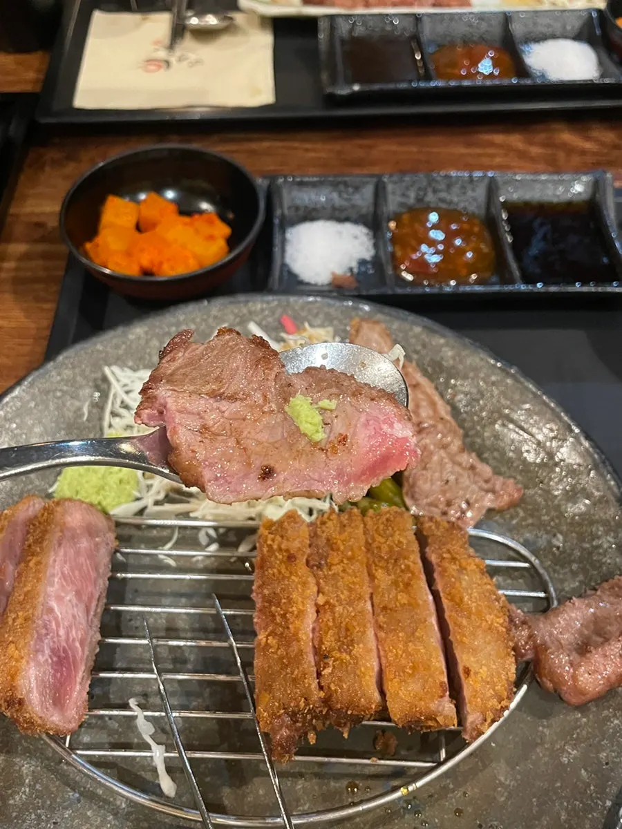 소스에 찍고 와사비를 올린 고기 한 점