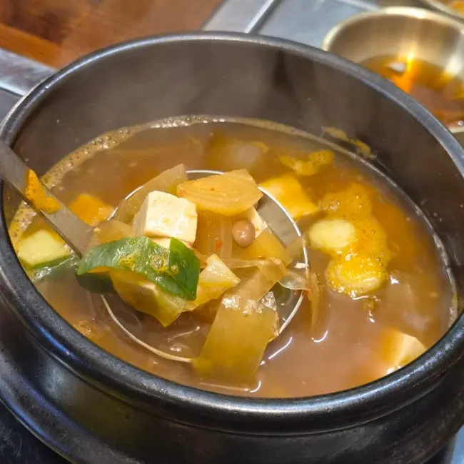 A bowl of seaweed soup with meat in it