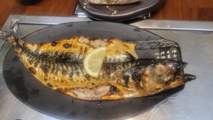 Close-up of grilled mackerel with a squeeze of lemon