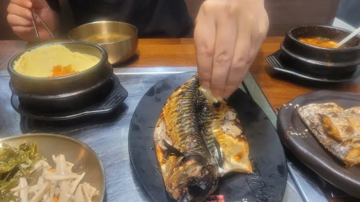A thick piece of mackerel pulled apart with chopsticks