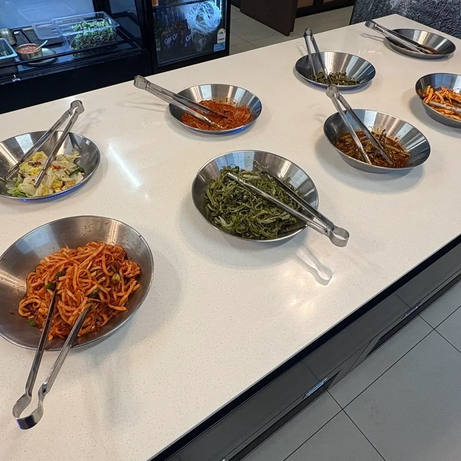 Side dishes displayed at Hwadamga's self-serve corner