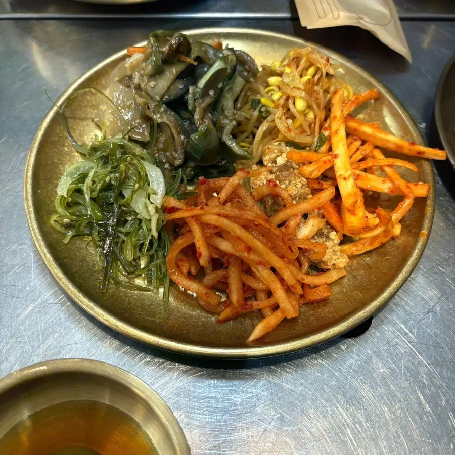 A bowl of seaweed soup with side dishes