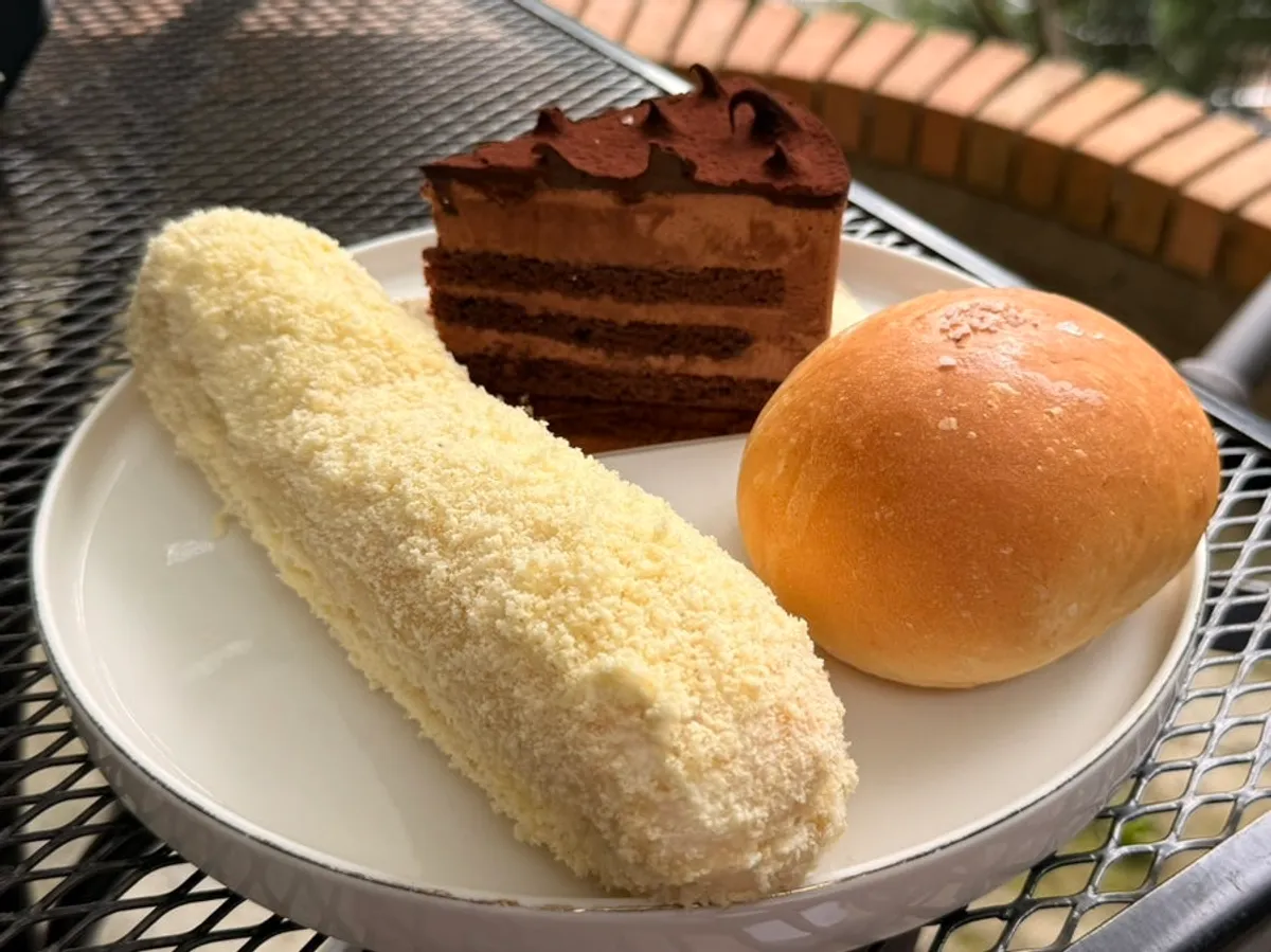 Table set with choco cake, bread, and two drinks