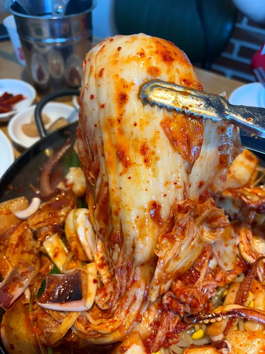 팬 위에서 섞이는 오징어와 돼지고기 두루치기